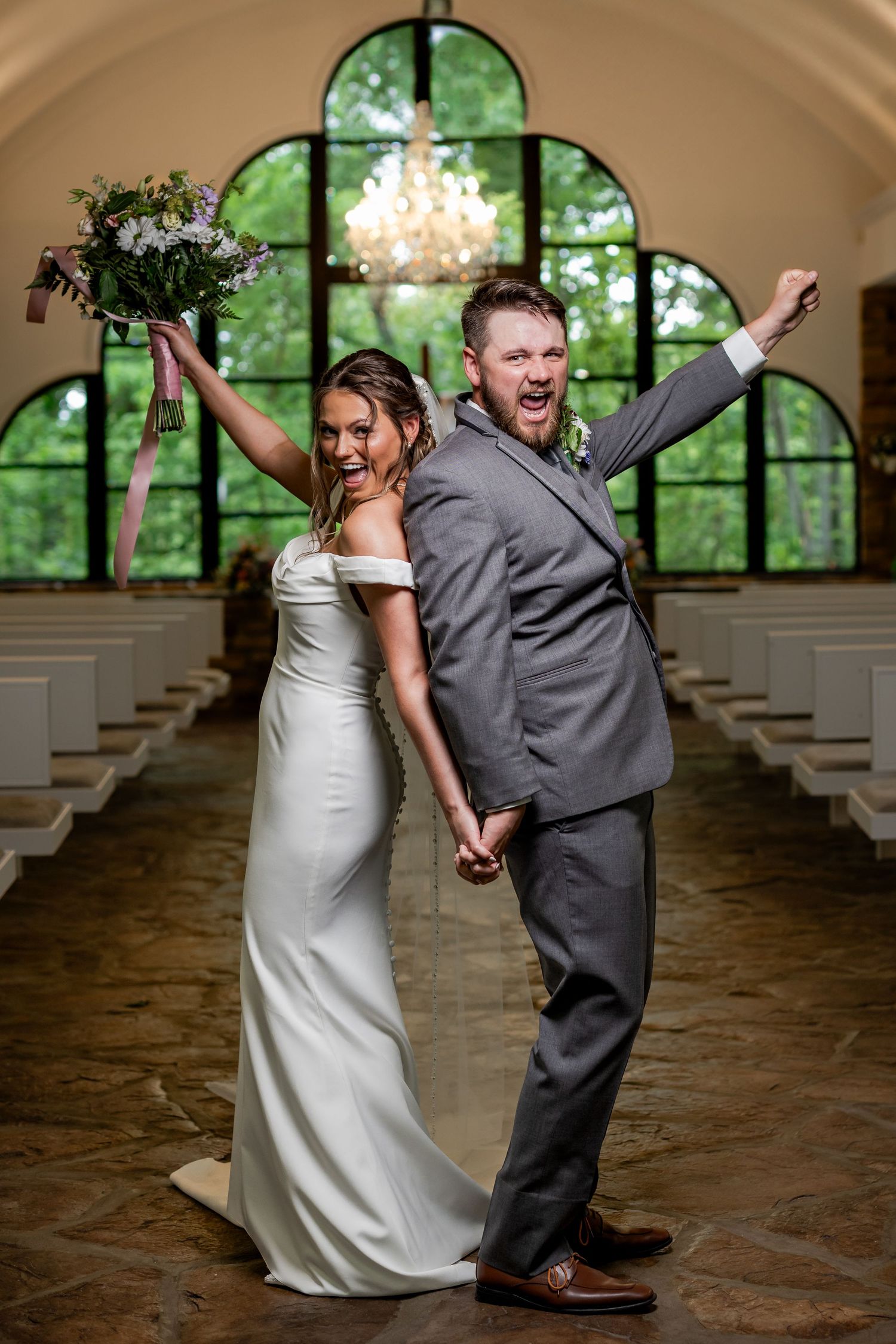 Bride and groom celebrating with hands raised after their Eureka Springs, Arkansas wedding
