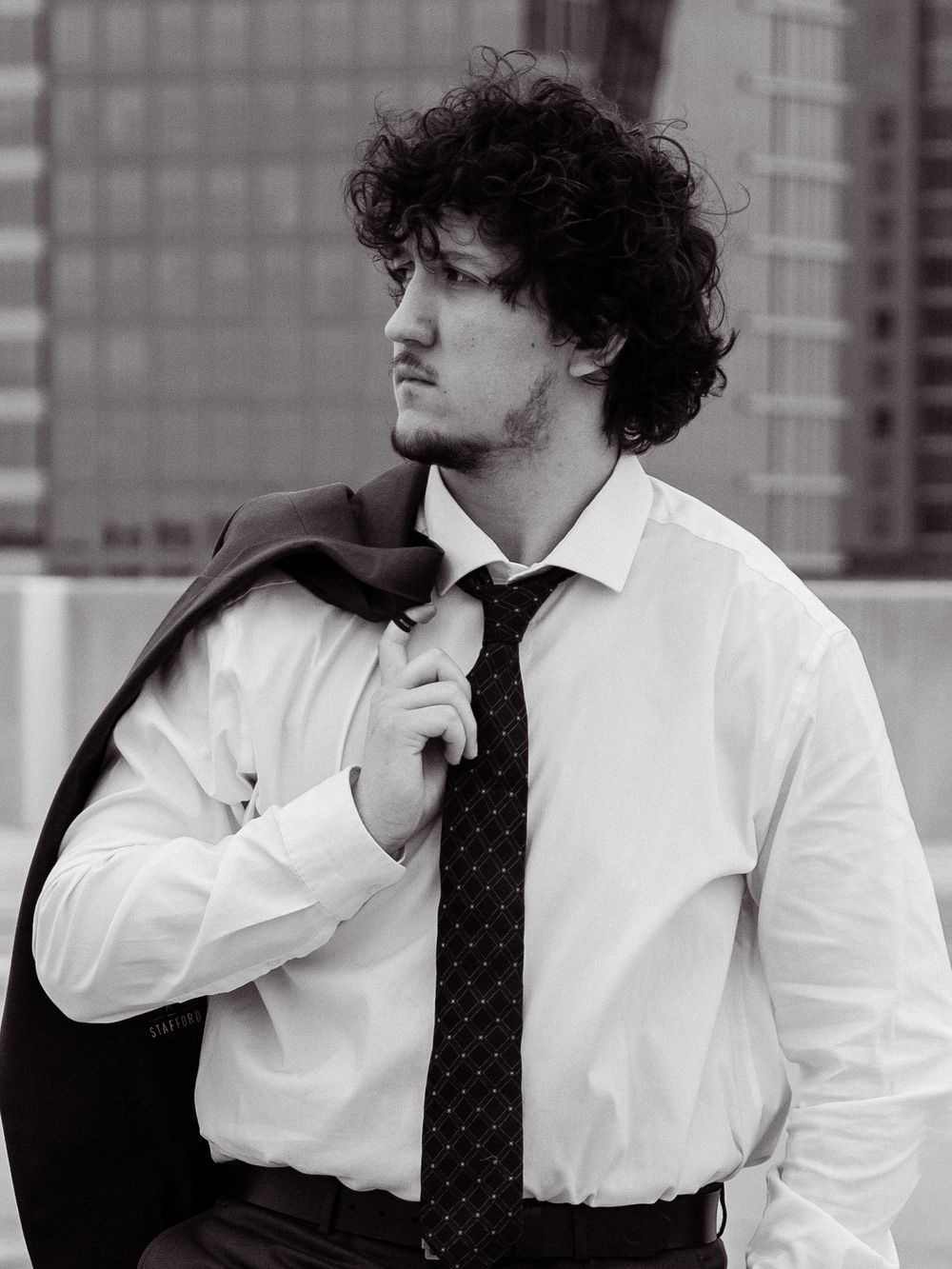 Black and white portrait showing business attire against cityscape.