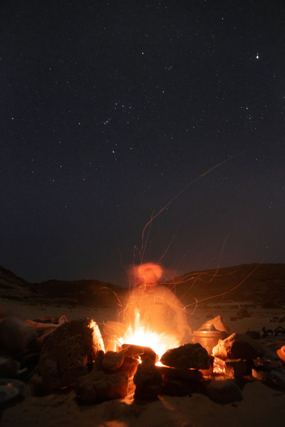 starry night photography of a bedouin around a bonefire in the desert of sinai