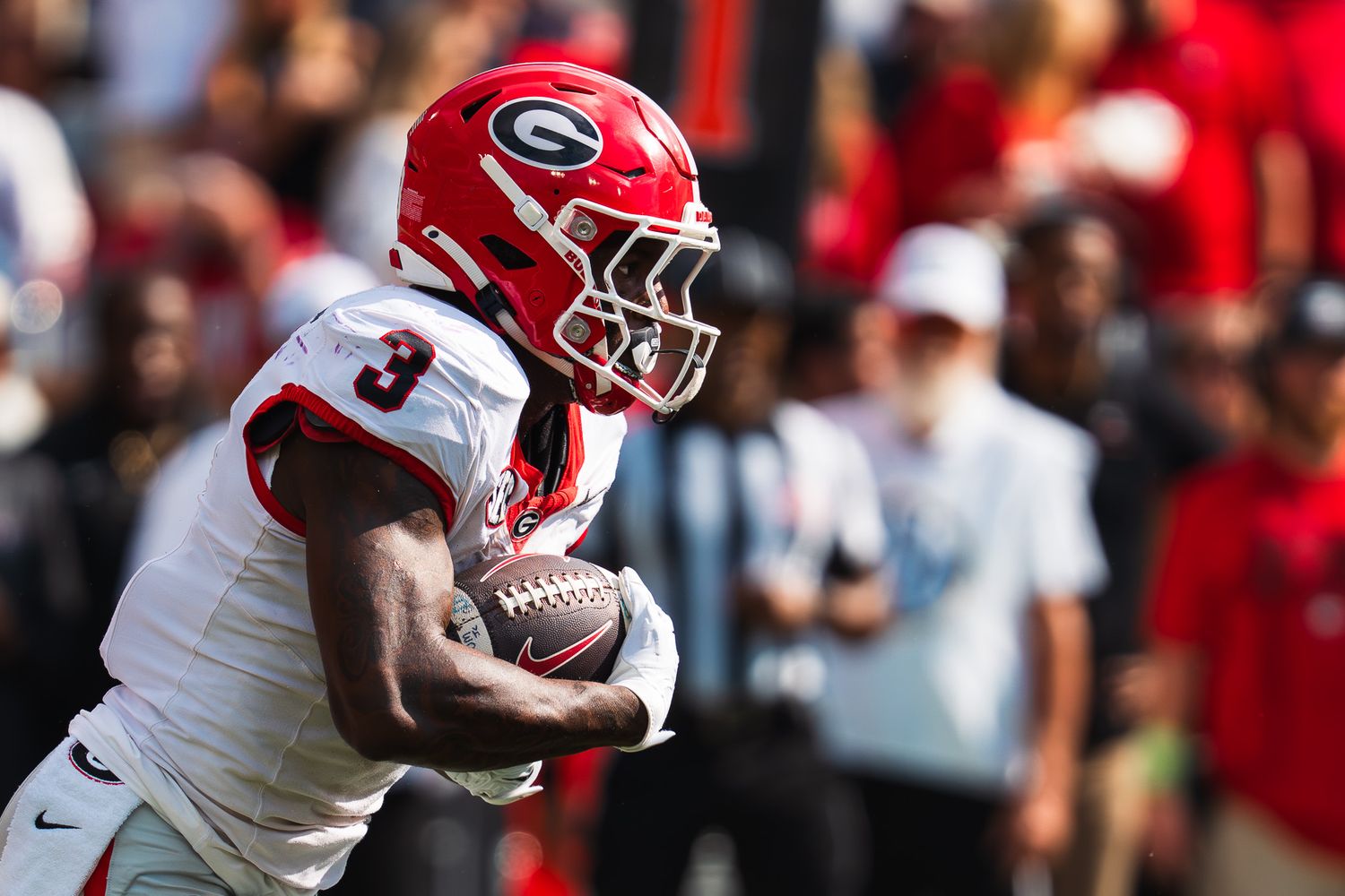 Georgia Bulldogs football player runs with ball during game action.