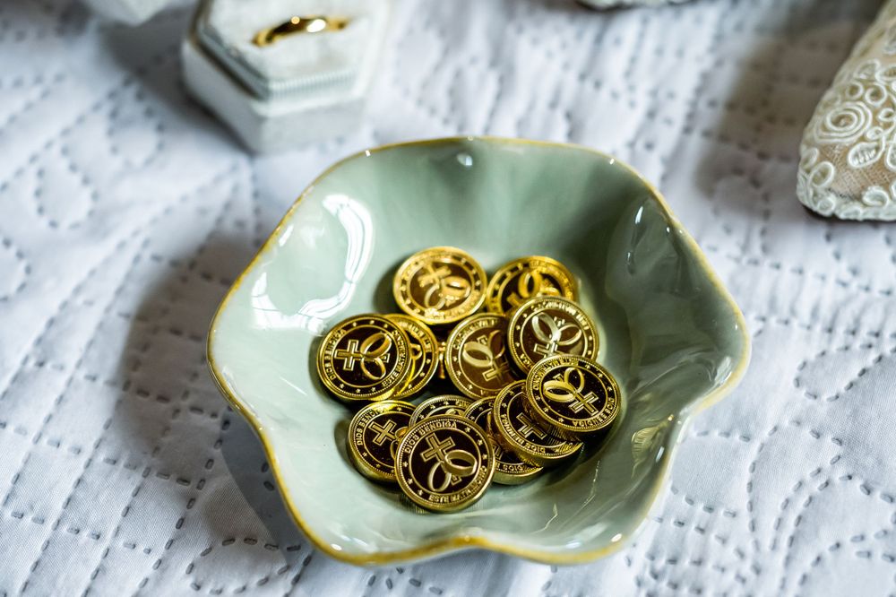 Gold wedding rings arranged on mint green decorative plate.