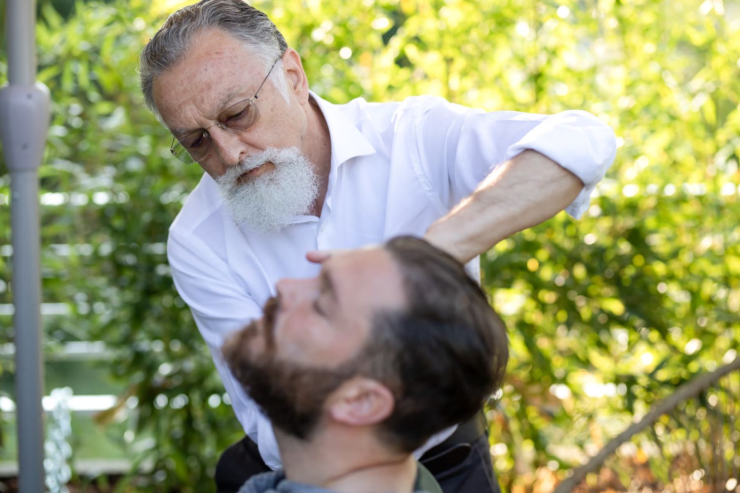 Man getting professional grooming service outdoors in natural lighting.