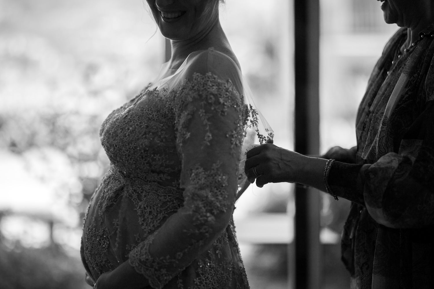 Silhouette of wedding preparations against window light.
