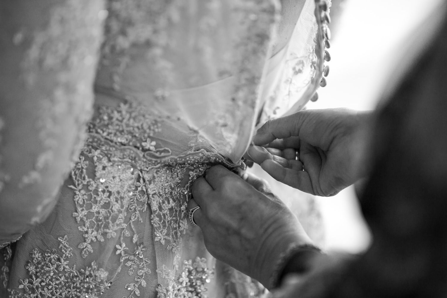 Close-up detail of intricate beading and lace on a peach-colored wedding dress.