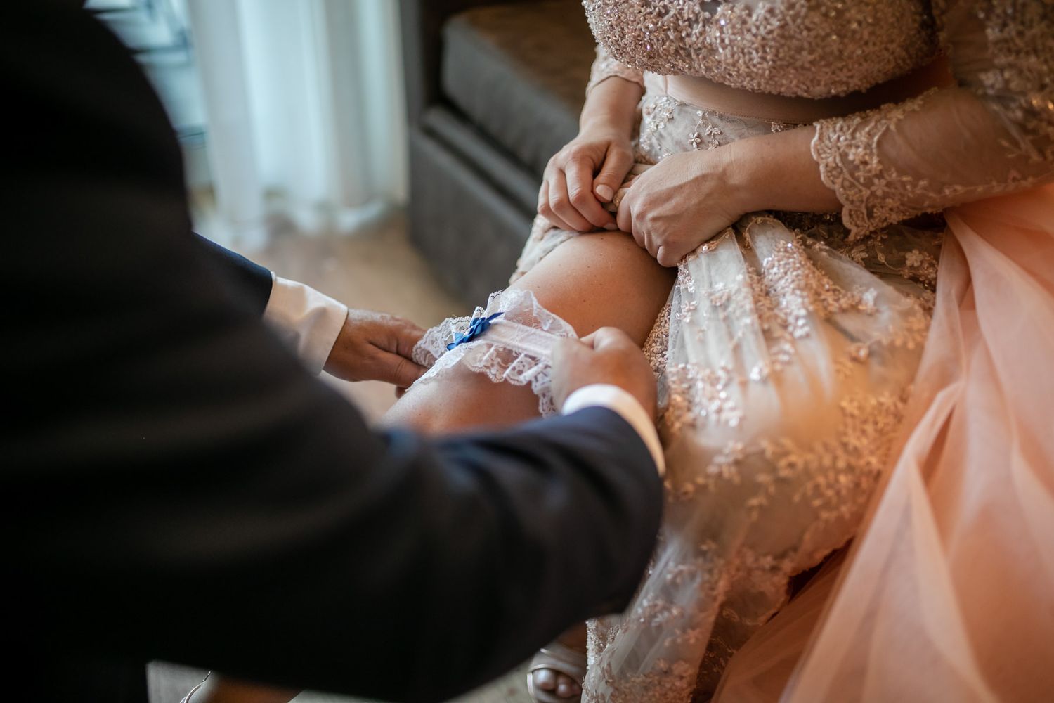 Detailed shots of someone adjusting delicate beadwork on a peach-colored gown.