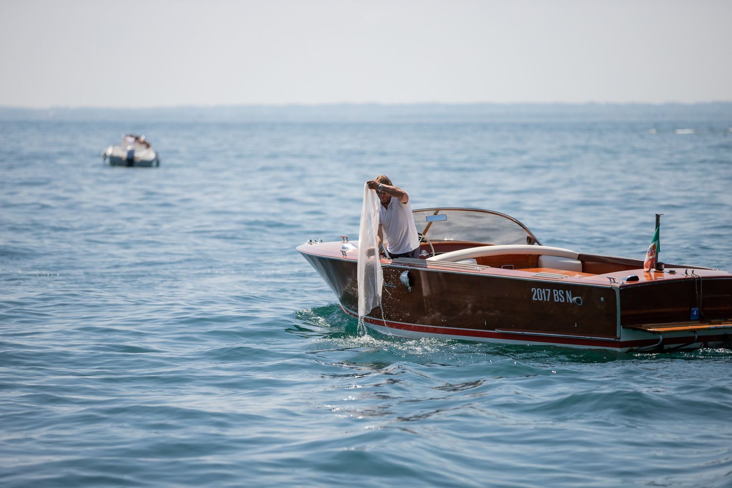Classic wooden boats sailing on calm blue waters near mountainous coastline.