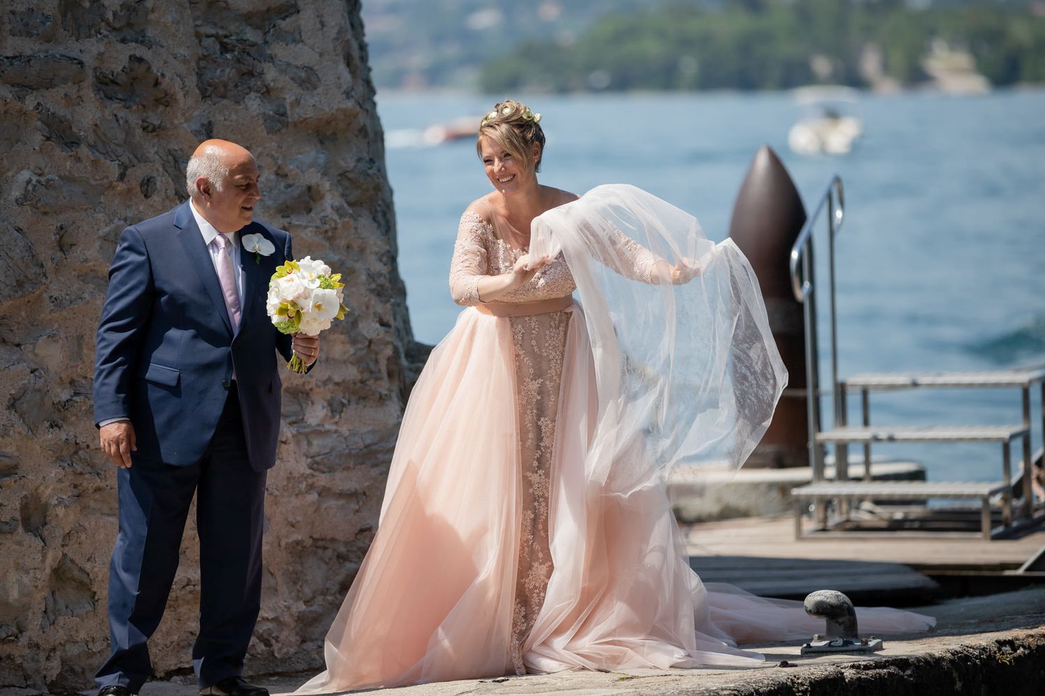 A wedding ceremony setup at a seaside venue with elegant white decor and stone architecture.