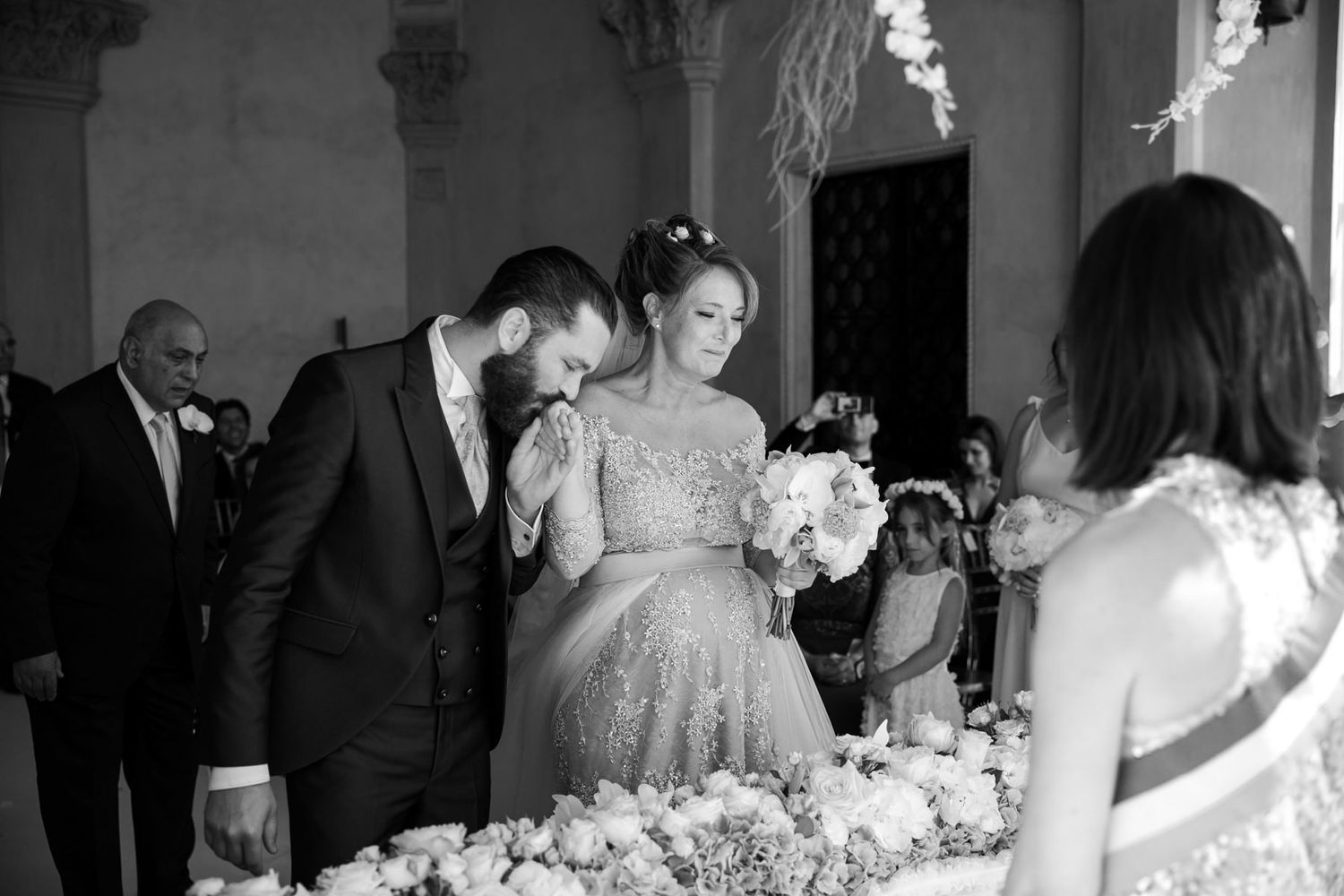 Black and white photo of wedding reception guests mingling at elegant venue.