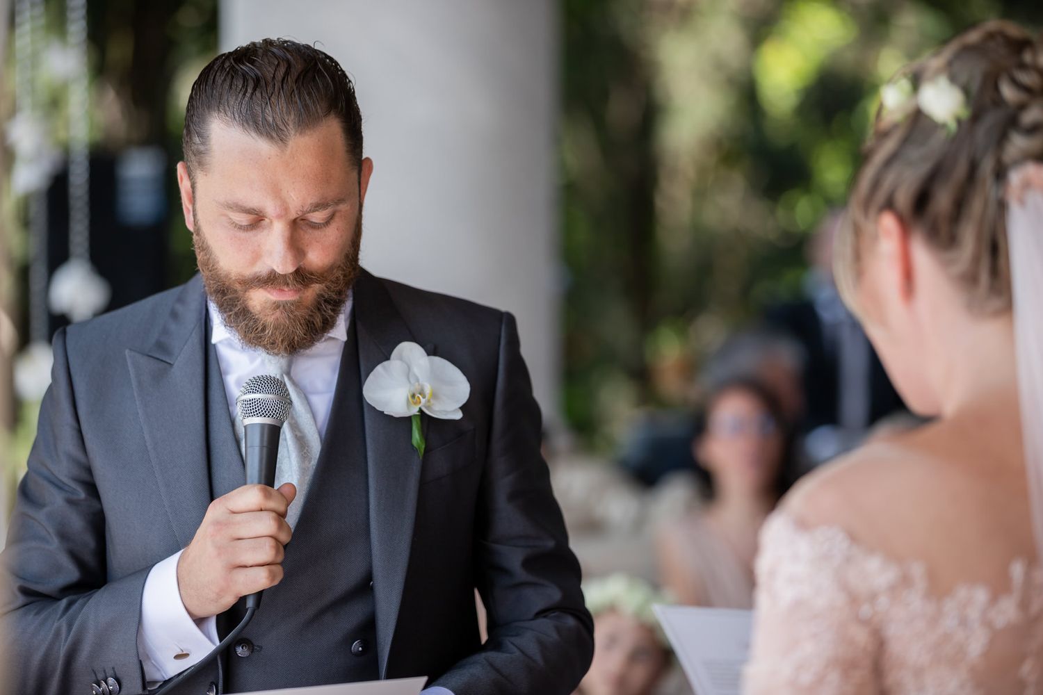 An intimate wedding ceremony moment captured between stone pillars and natural light.