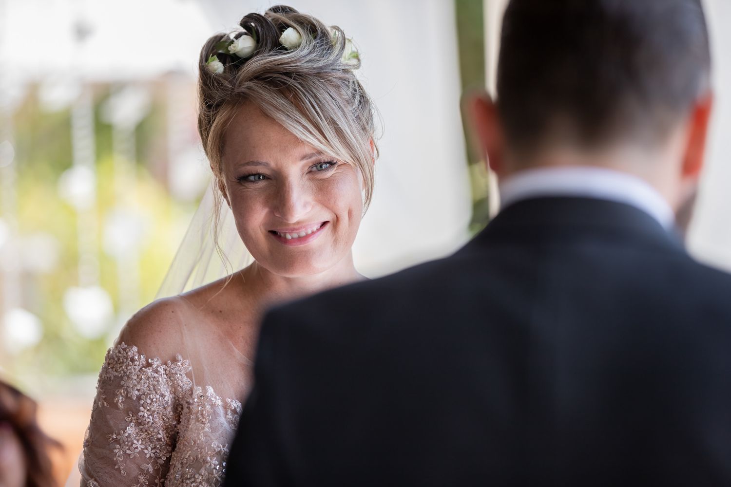 Wedding couple exchanging vows during intimate ceremony under elegant architecture.