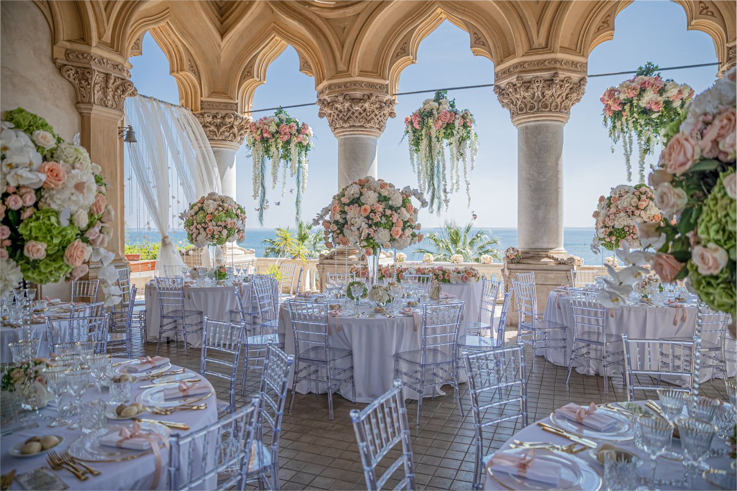 Luxurious wedding reception venue with gothic arches and elegant white table settings.
