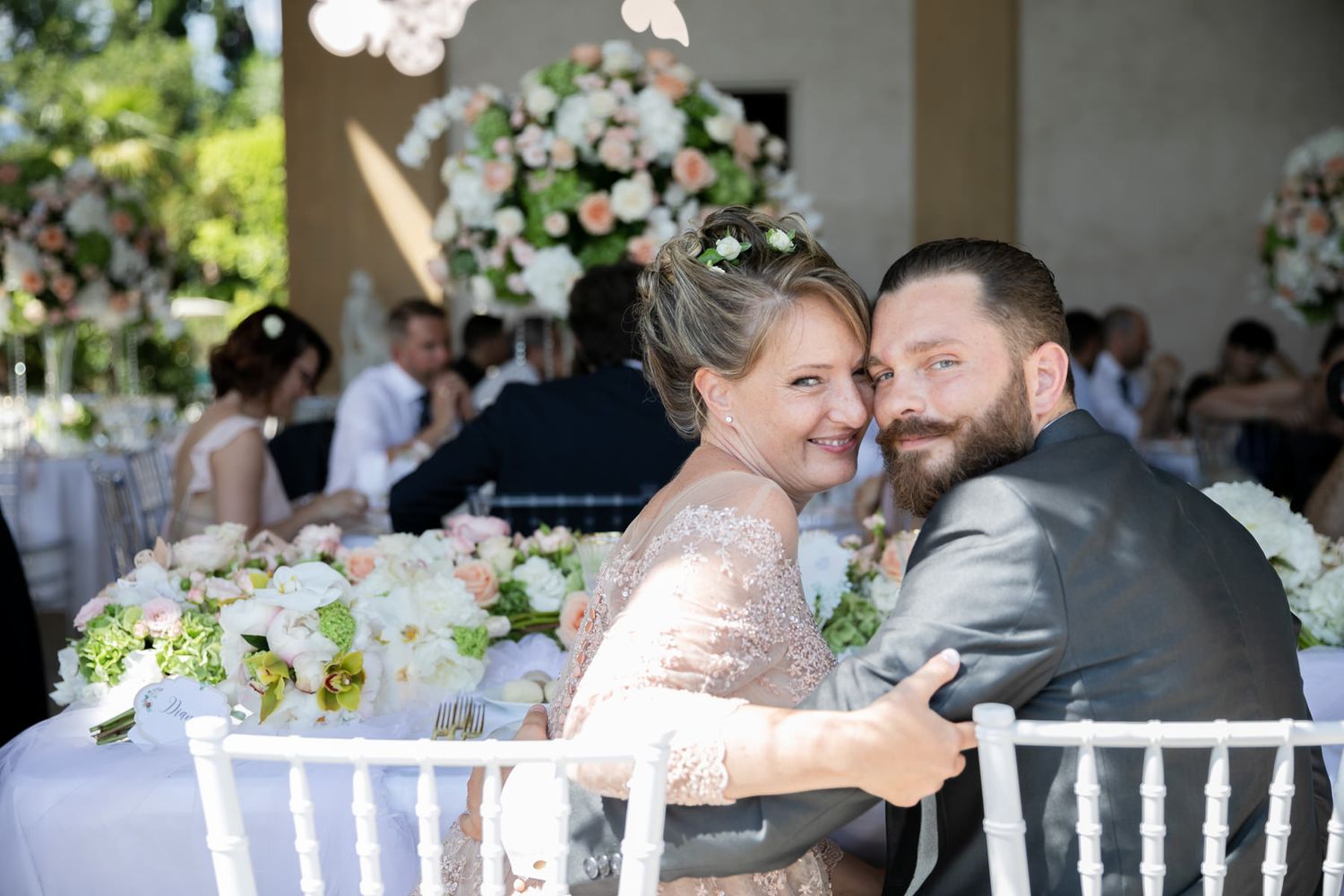 Wedding reception dining area with white chiavari chairs and intimate table settings.