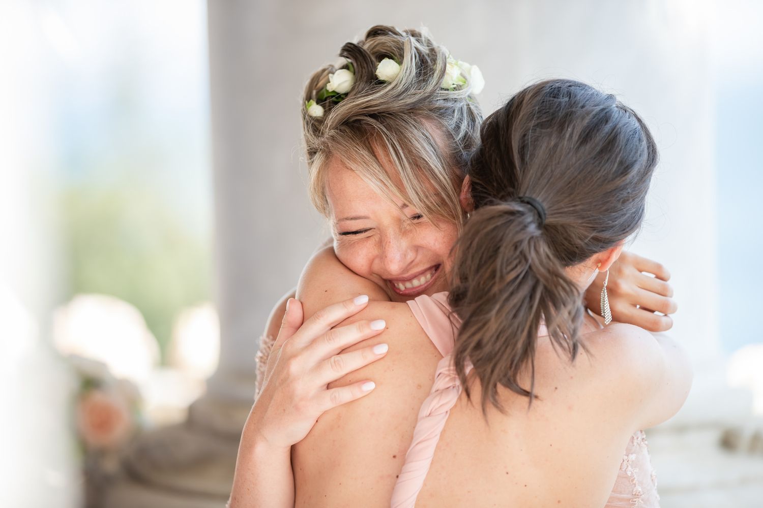 Emotional wedding moment captured in bright, airy indoor setting.