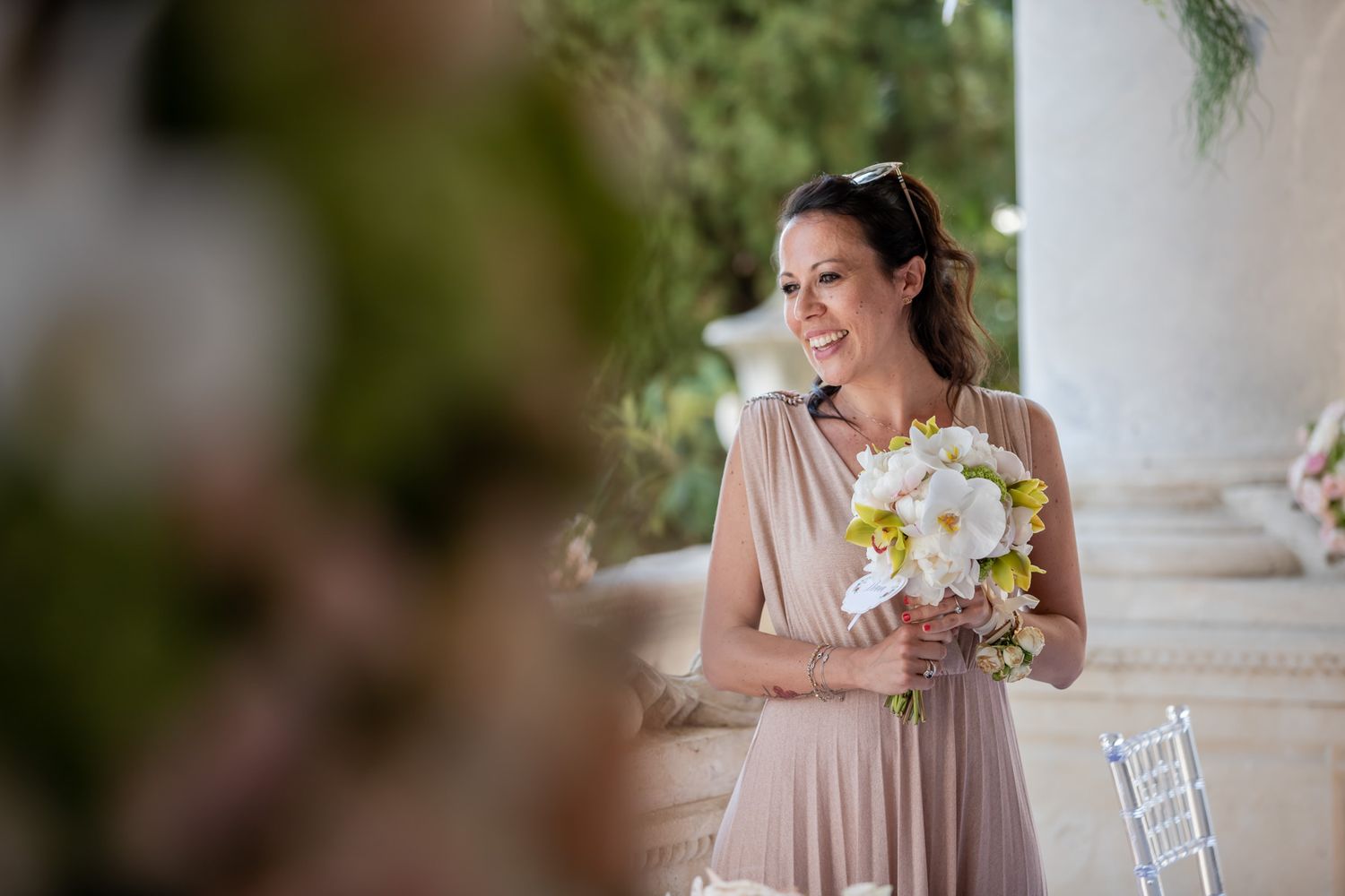 Wedding celebration in an elegant columned venue with natural lighting.