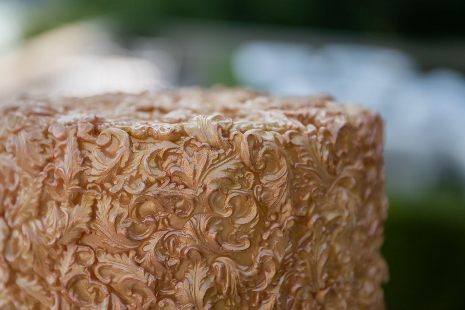 Intricate textured wedding cake with delicate gold details and multiple tiers.