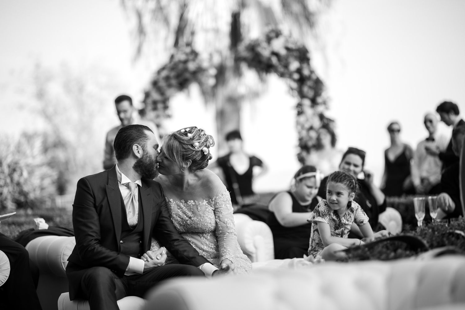 Black and white photo of wedding guests enjoying the outdoor celebration.