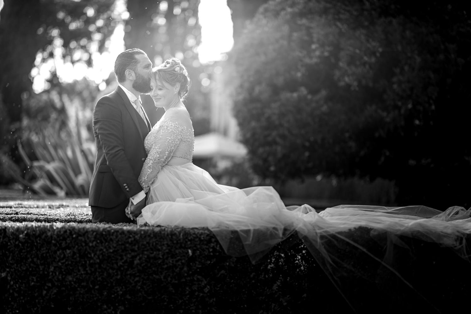 Black and white romantic portraits of a couple in an outdoor garden setting.