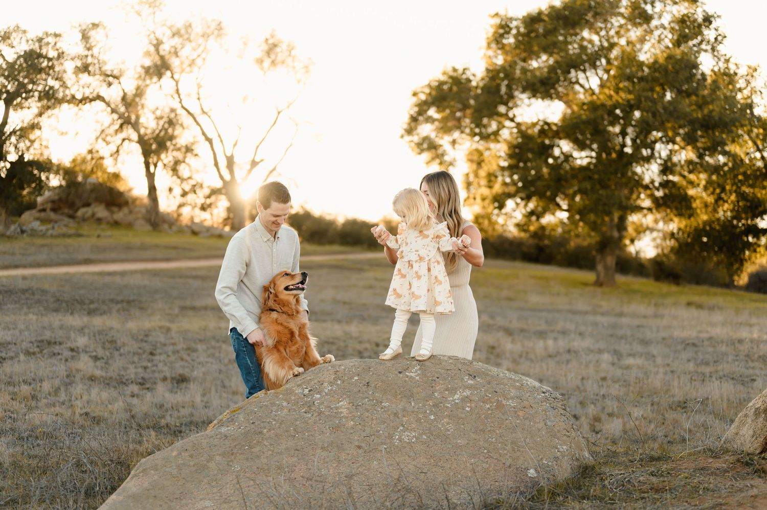 Family of three playing with their dog at a golden field in Ojai by Ventura maternity and family photographer
