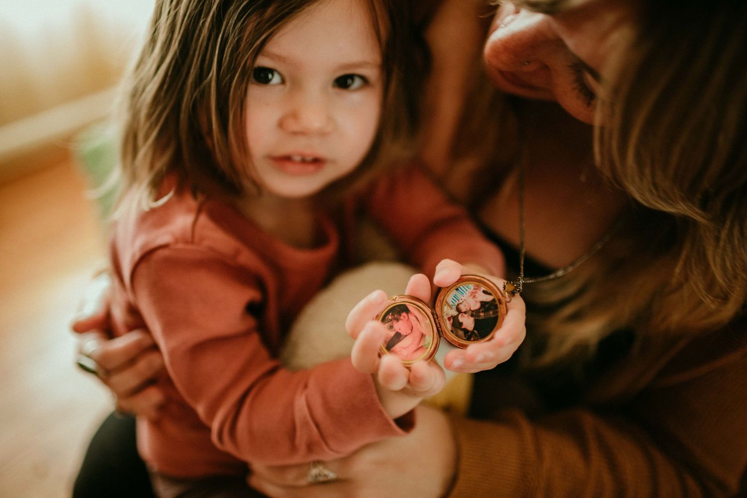child shows camera pictures in locket. portland oregon rushes & waves kimberly marie kimble