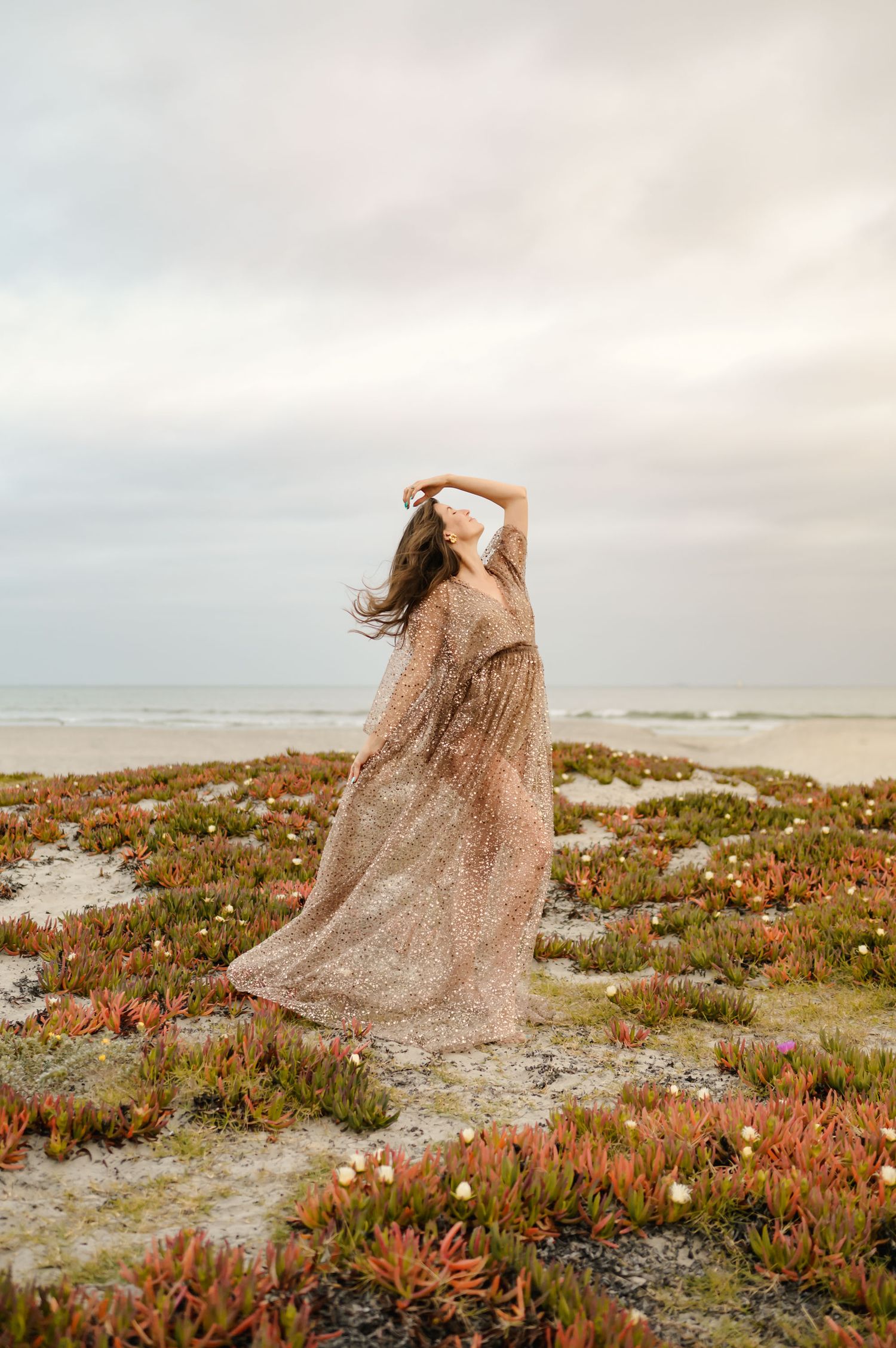 maternity beach photoshoot at Zachari Dunes Mandalay beach by Ventura maternity photographer of woman in sheer dress dancing on beach dunes