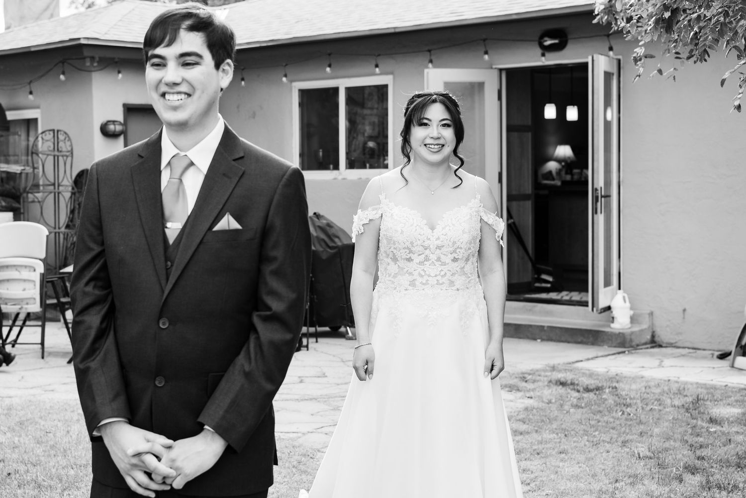 Black and white first look photo with couple outside building.