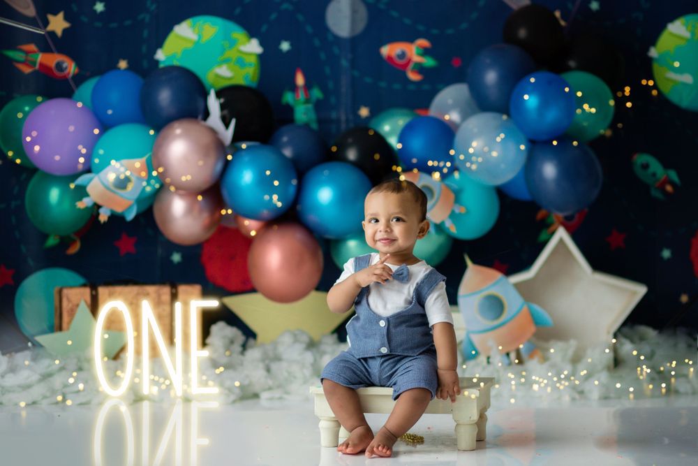 Space-themed first birthday setup with glowing neon lights, stars, and cosmic balloon decorations.