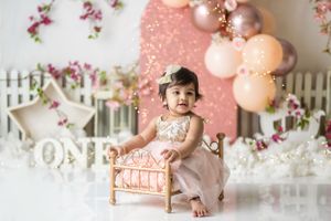 Decorated pink and white setting with ornate chair and floral accents.