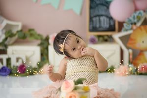 Soft pink studio setup with crown accessory and floral decorations.