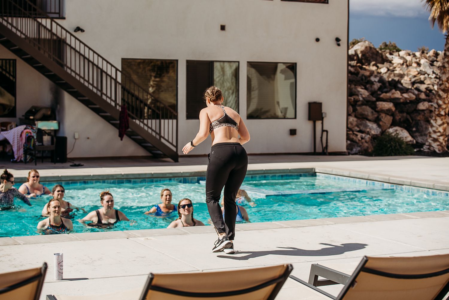 People enjoying pool party activities with swimmers and poolside entertainment.