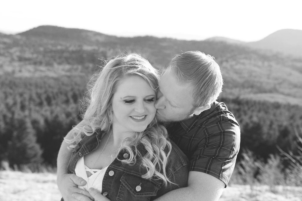 A romantic black and white portrait with mountain landscape in background.