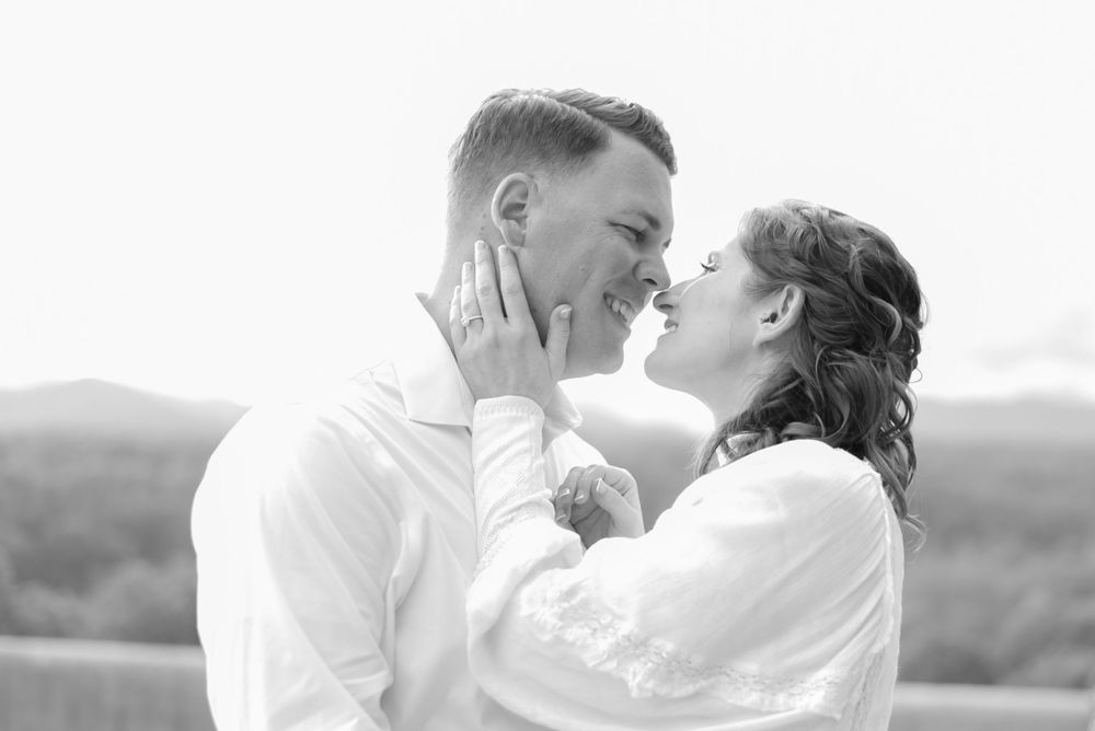 Black and white portrait of couple sharing an intimate moment outdoors.