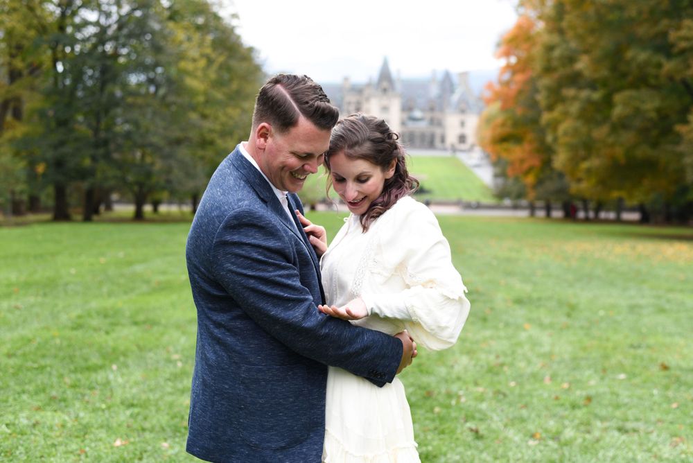 Couple in warm embrace on castle grounds during autumn season.