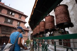 Traditional prayer wheels line a temple wall in Kathmandu, Nepal.