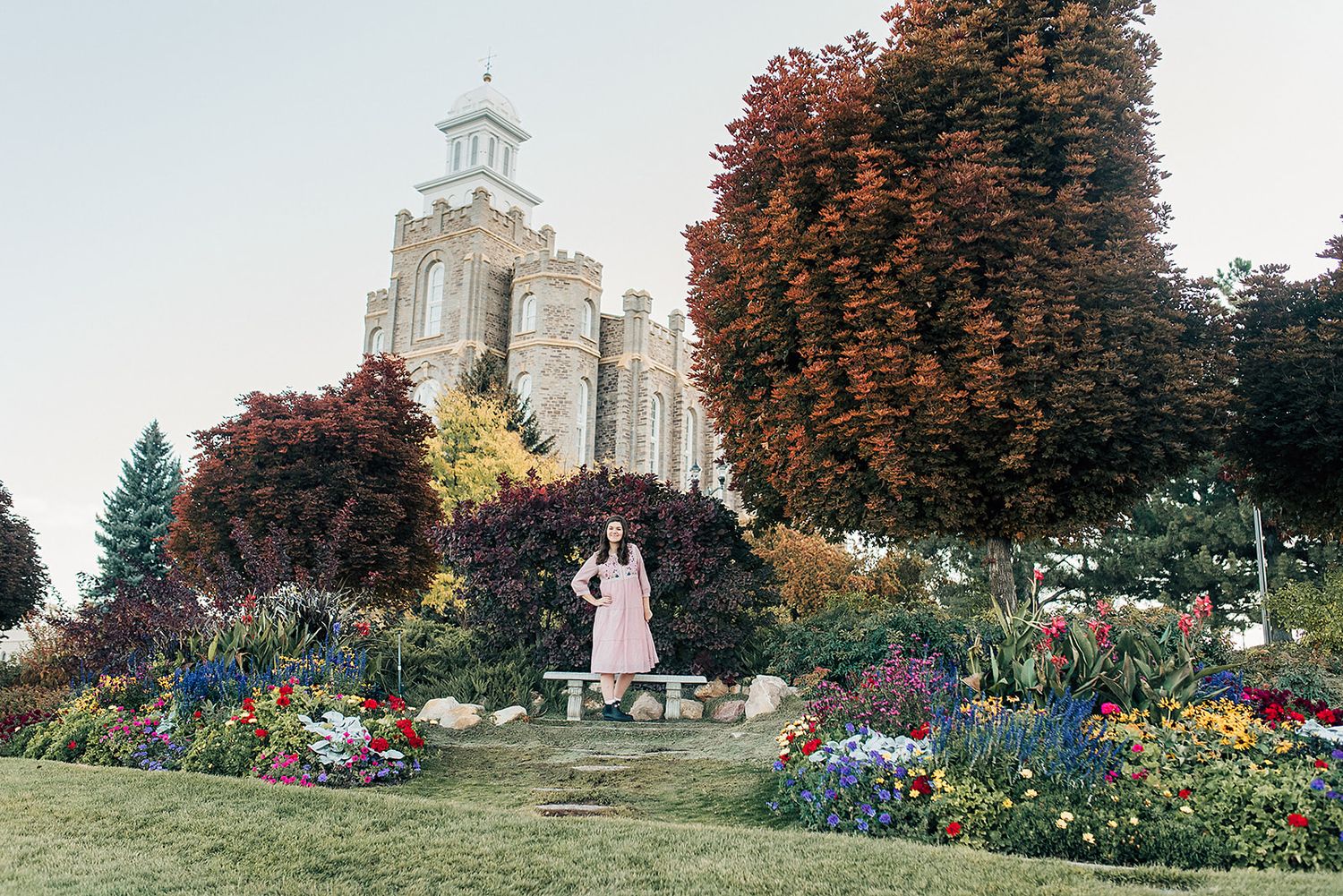 Beautiful garden with colorful flowers in front of a grand white temple building.