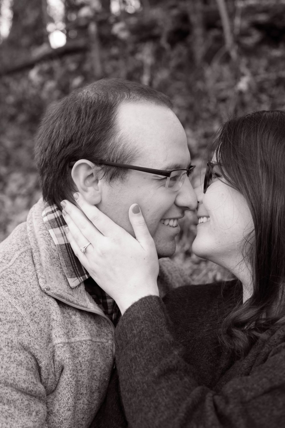 Black and white portrait of couple sharing an intimate moment outdoors.