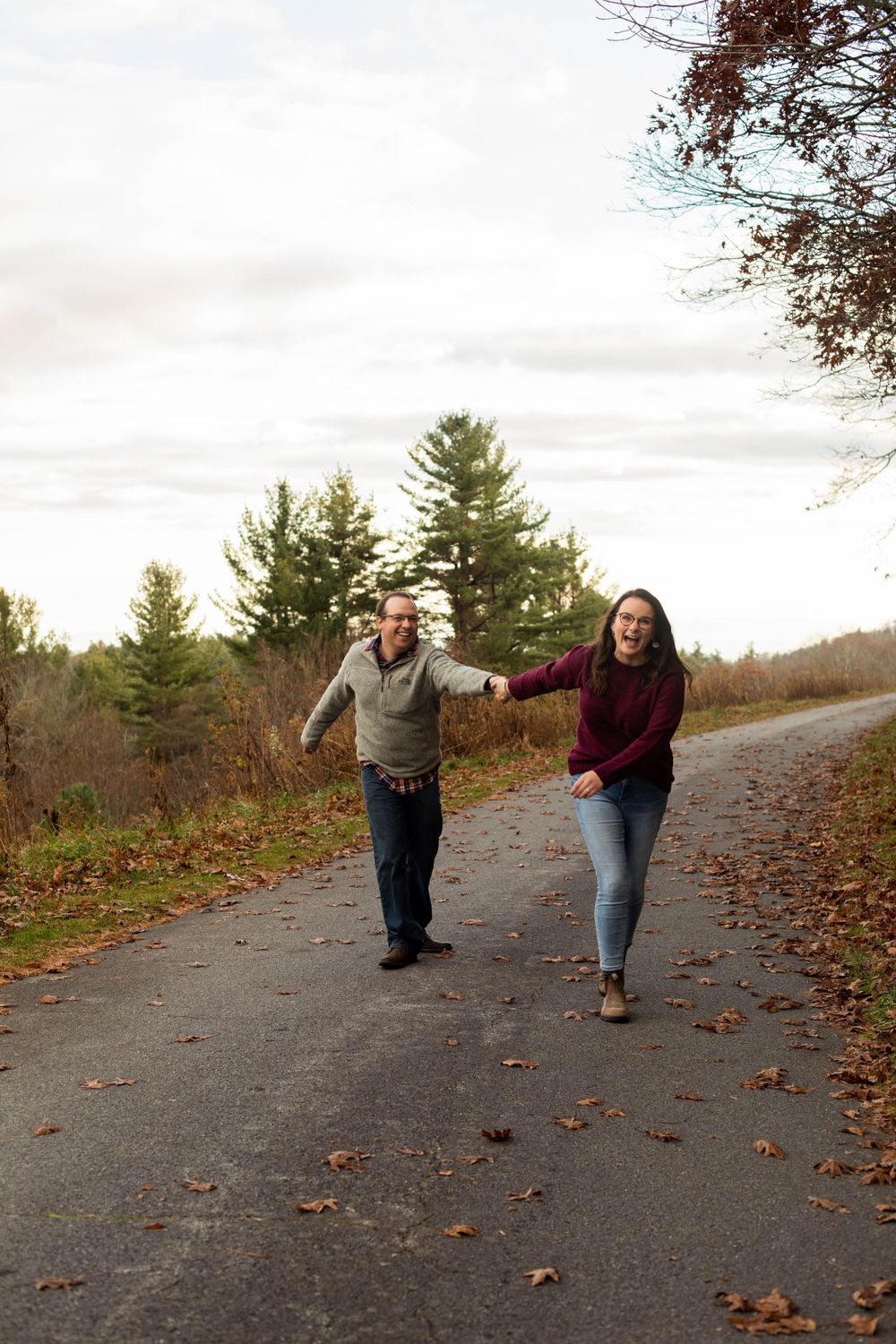 A playful sequence of a couple walking and dancing together on an autumn path.