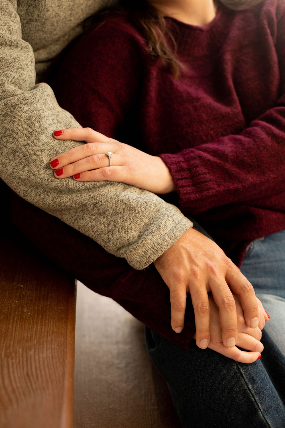 Close-up of hands resting together showing wedding rings.