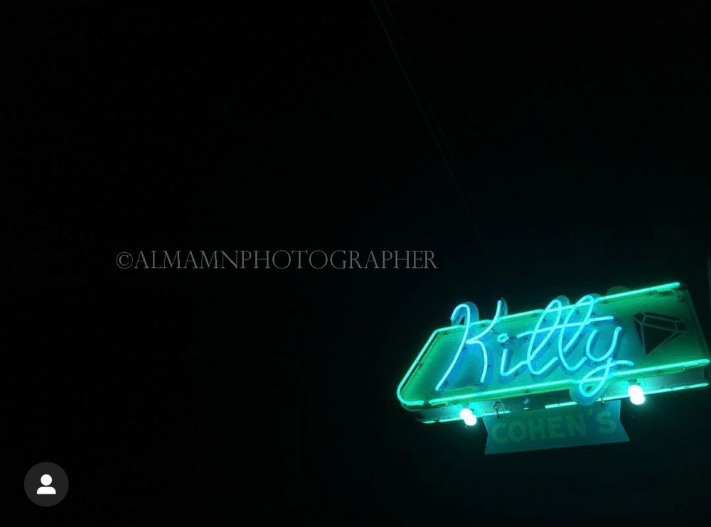 Neon sign glowing in blue against a dark night sky.