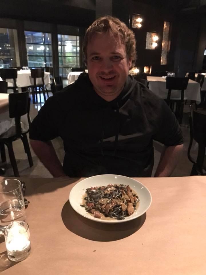 Restaurant dining scene with plated mushroom dish and candlelight on table.