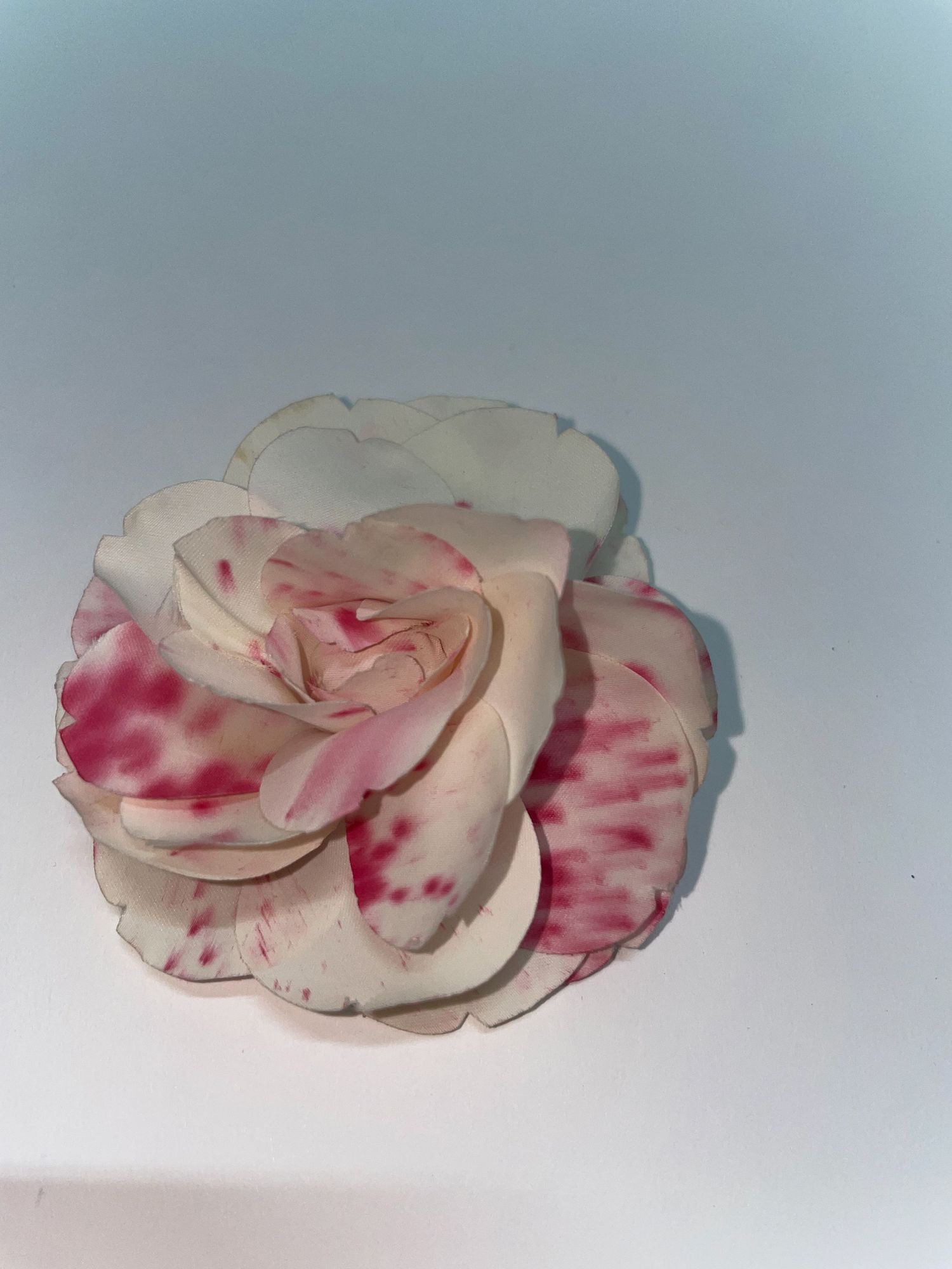 Delicate pink and white fabric flowers with watercolor-style red accents.