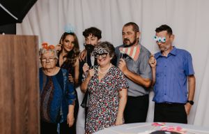 Group of wedding guests enjoying photo booth props at reception celebration.