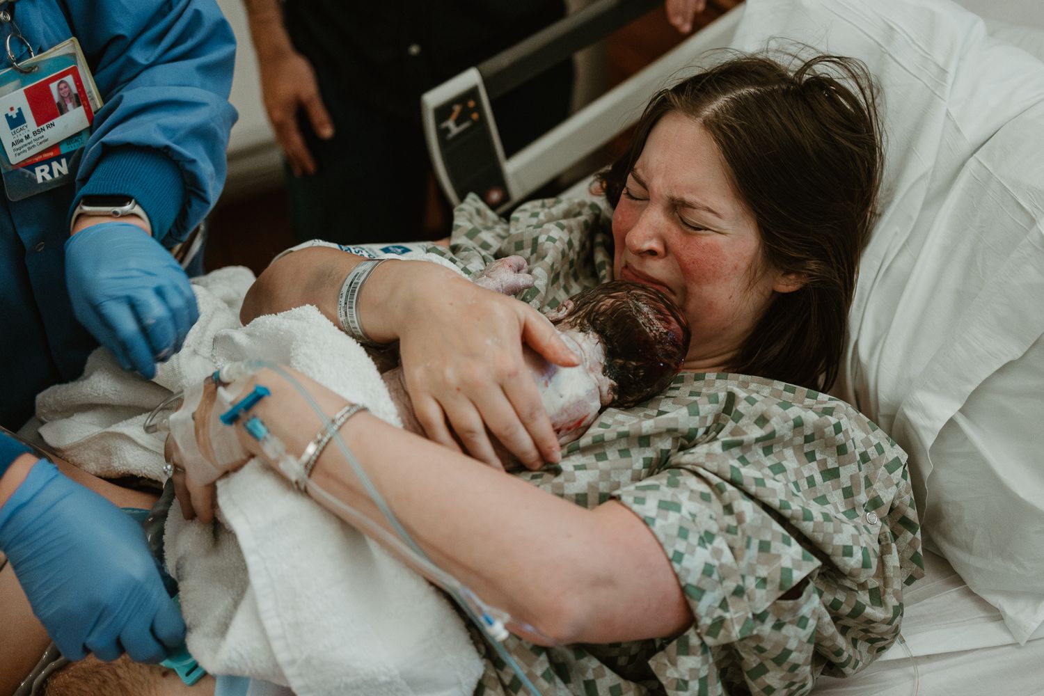 An emotional moment of a new mother holding her newborn baby in the hospital.