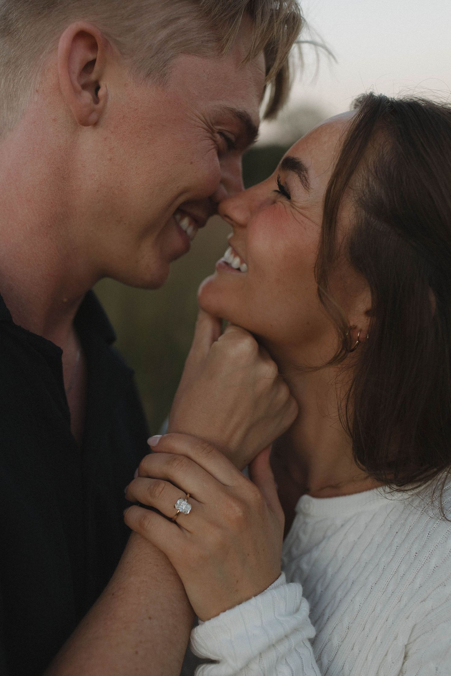 Close-up of tender romantic moment between couple in white sweater.