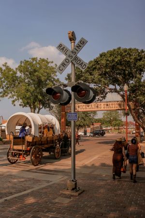 Vintage covered wagon and railroad crossing sign in a historic downtown district.