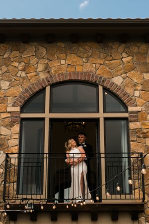 A couple enjoying the moments before walking down the aisle framed by the window they are standing on