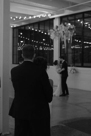 Father and Mother watching their daughter have her first dance with her husband, shot in black and white