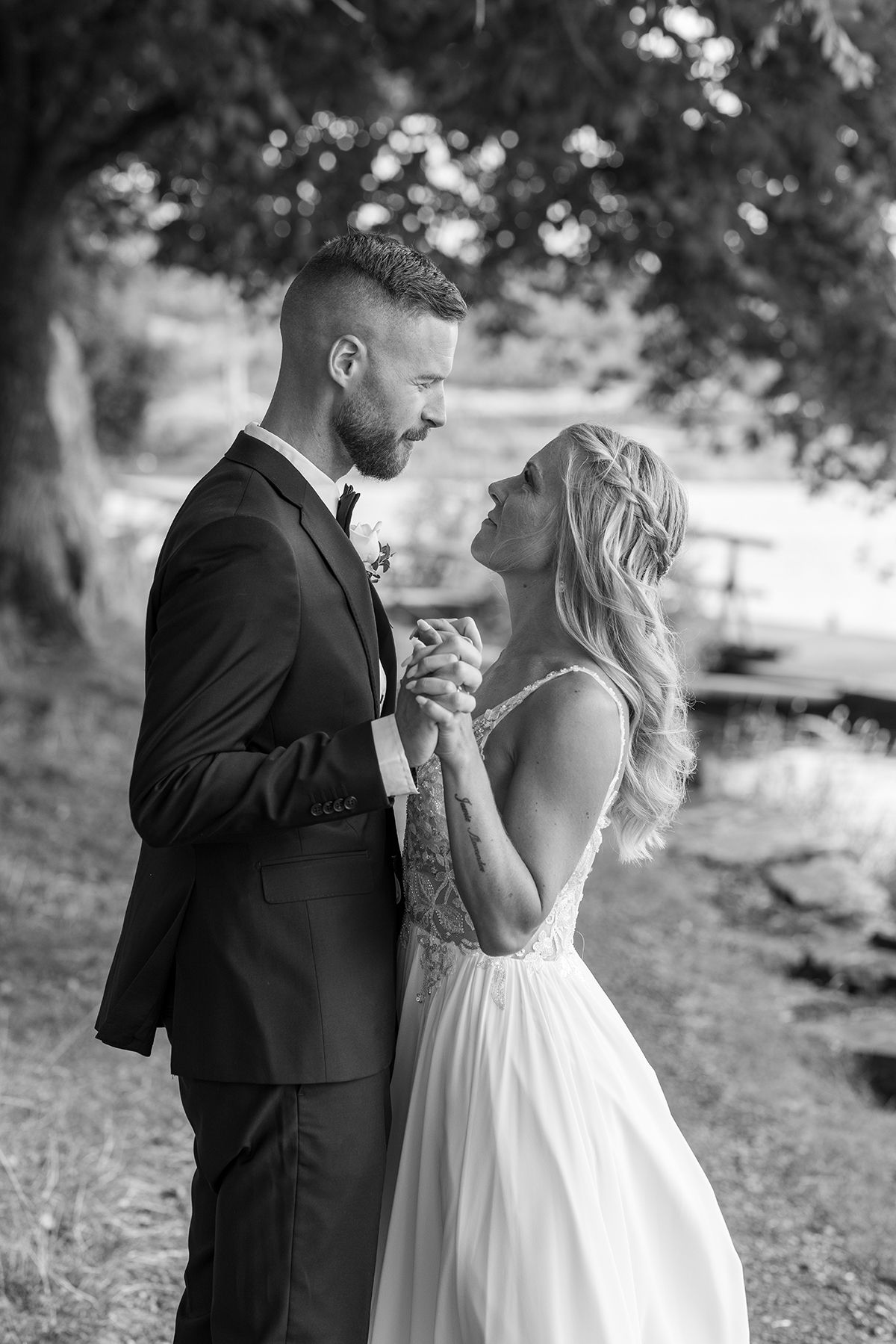 Porträttfotografering med brudparet. De håller i händerna och dansar