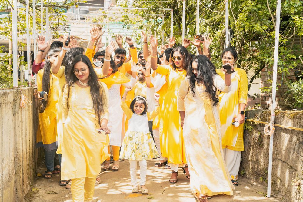 A joyful group in vibrant yellow outfits celebrating together on an outdoor pathway.