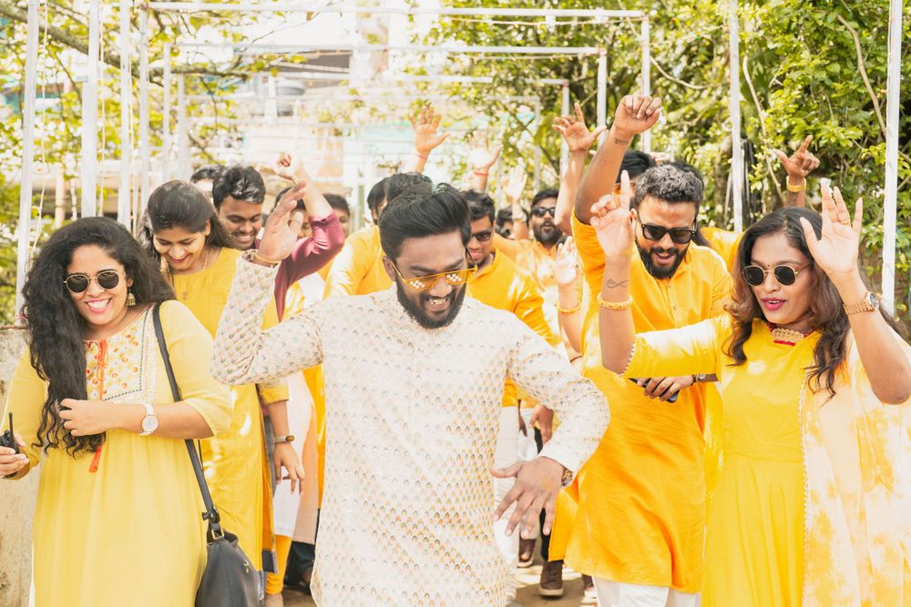 Celebration procession with people wearing coordinated yellow and white outfits walking together.