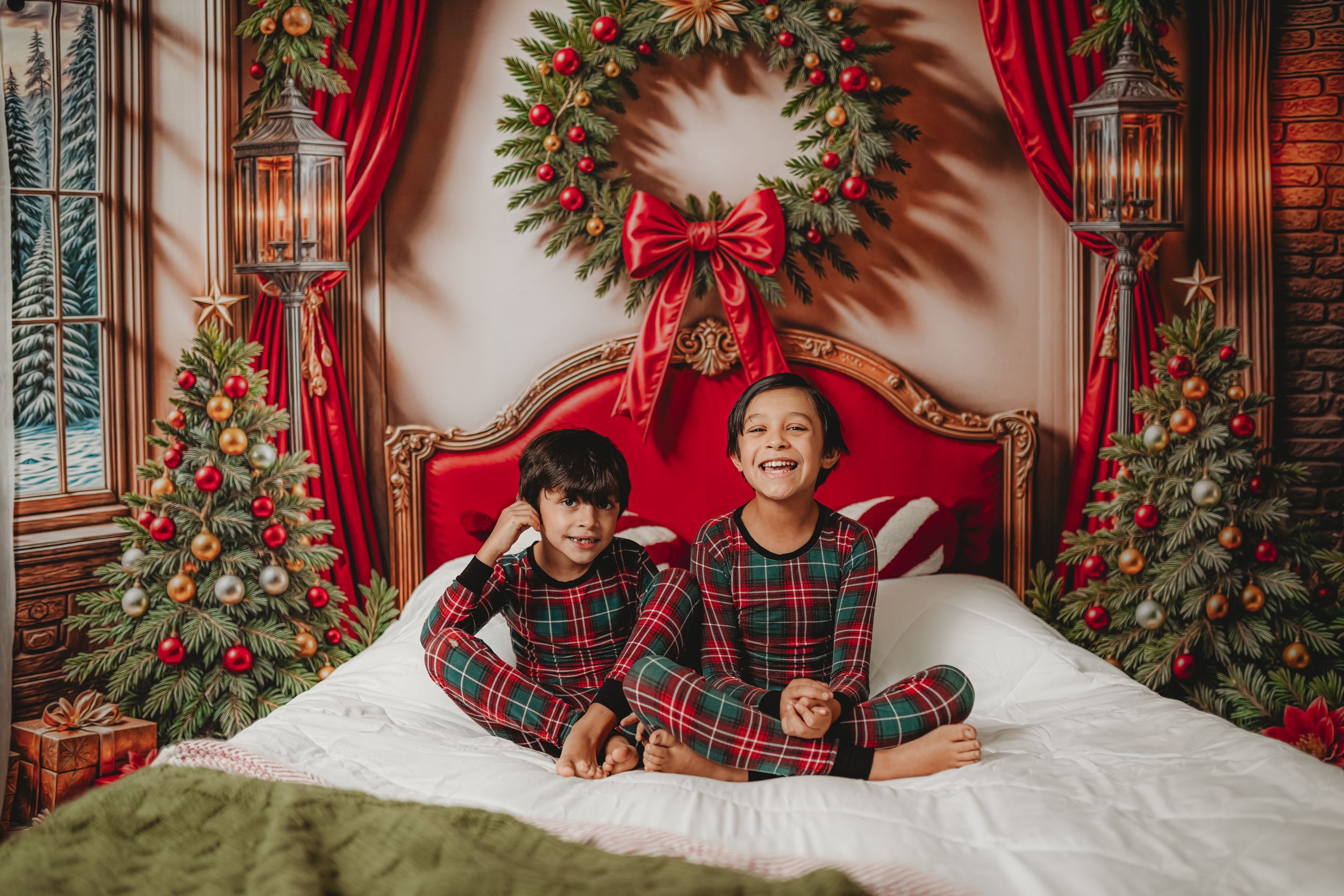 Christmas themed photography set with red curtains, wreaths and festive decorations.